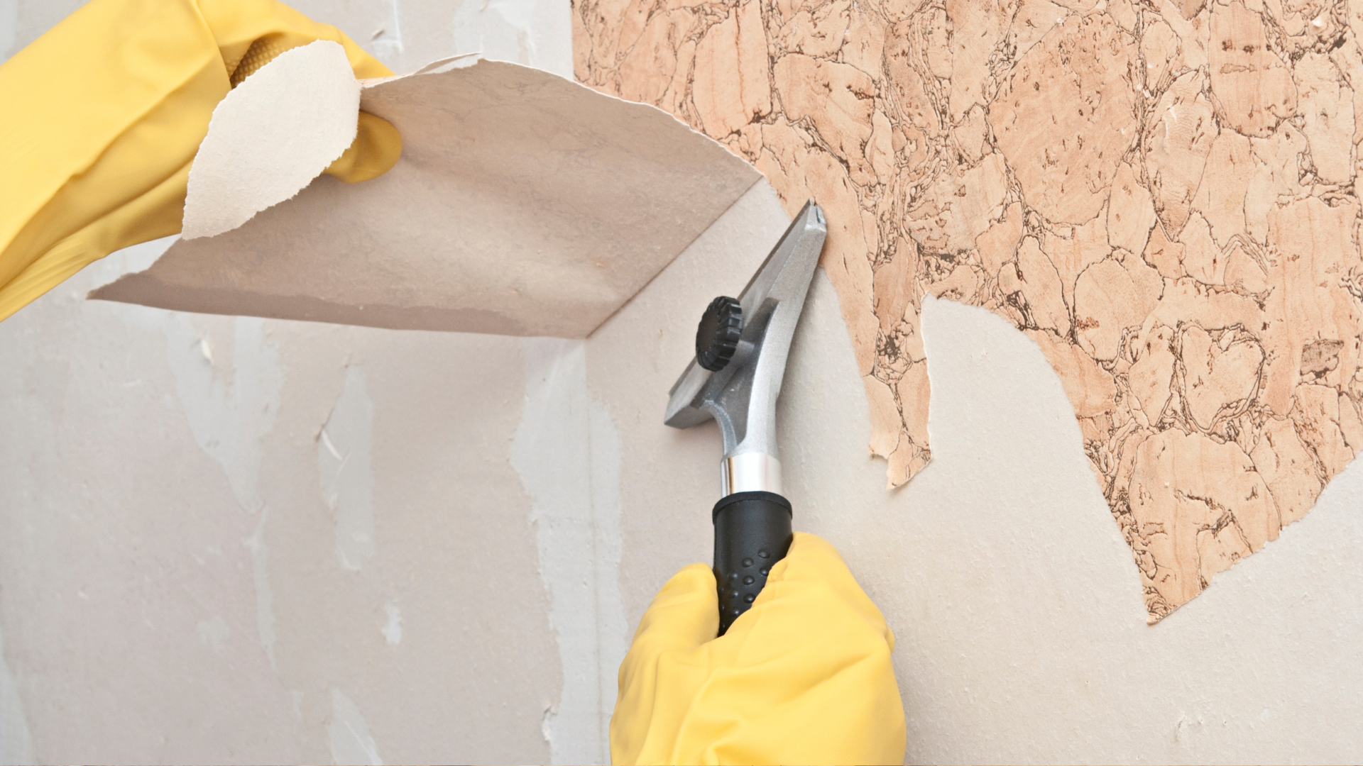 A person in yellow gloves and yellow gloves painting a wall