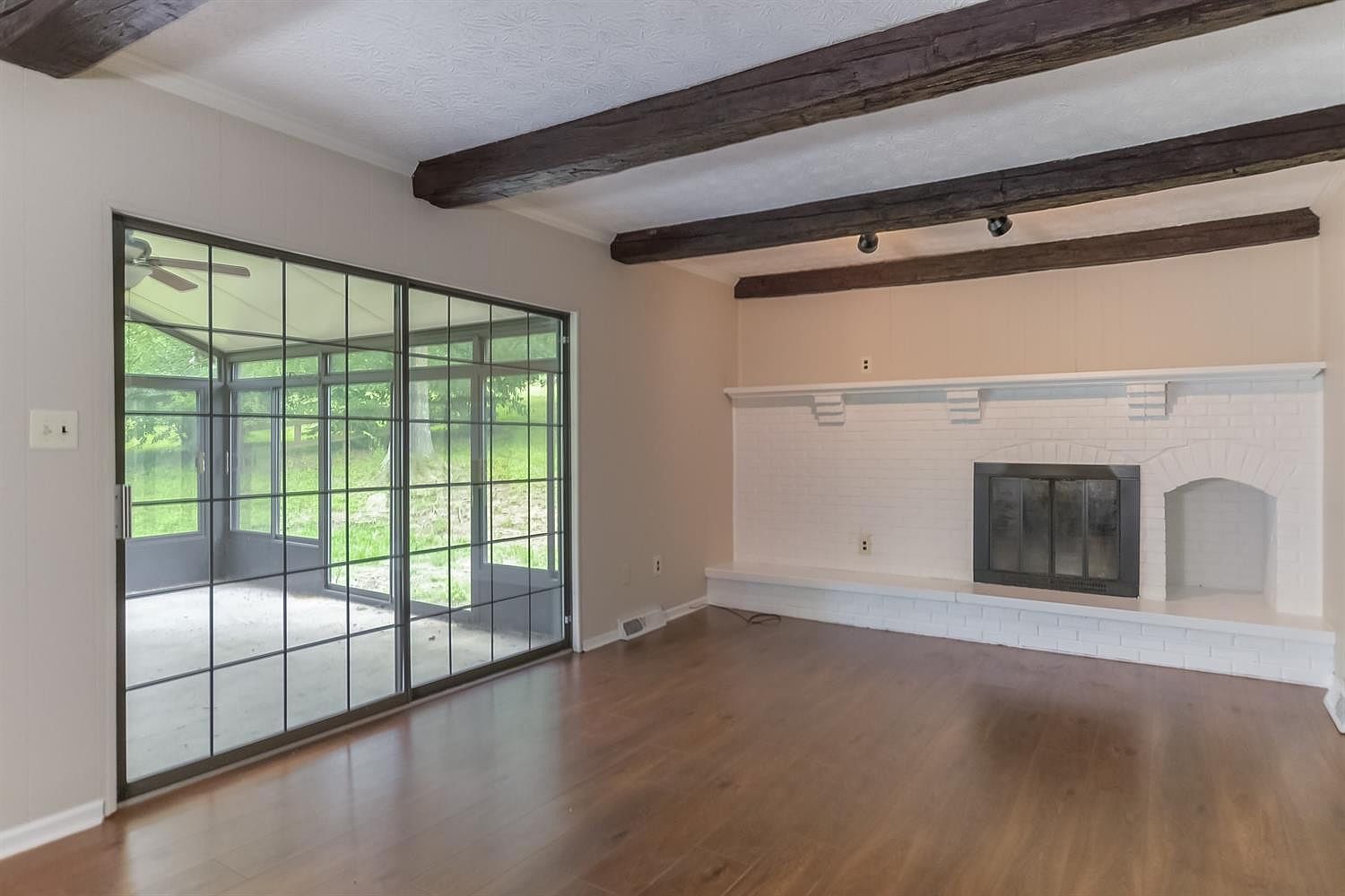 Freshly painted family room with exposed beams and a white brick fireplace – Idylwild Drive, Richmond, KY